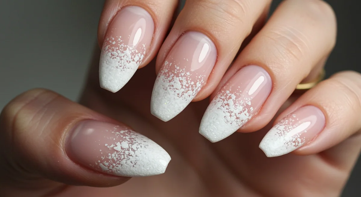 Frosted tips nail art with shimmering white gradient on almond nails