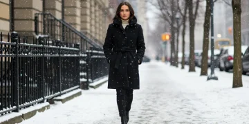 Woman in stylish winter 2025 coat in snowy city